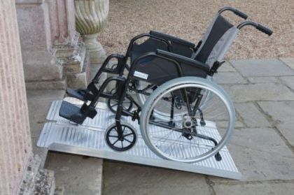 Погледната отстрани, поставена на пода рампа за инвалидни колички за достъпност за хора с увреждания.
