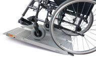 Инвалидна количка върху рампа за изкачване на стълби (достъпна среда за хора с увреждания)