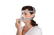 Пациентка със сънна апнея поставя CPAP маска на лицето си - Resmed Quattro Air. 